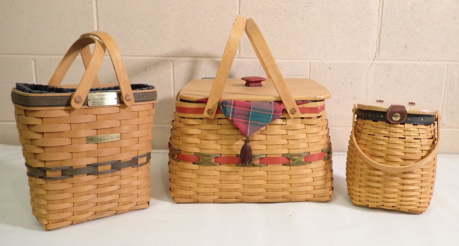 3 Longaberger Baskets: Largest is approx 13 1/2" x 13 1/2" x 9" tall. 2 on left have protectors and liners. One on right just has protector