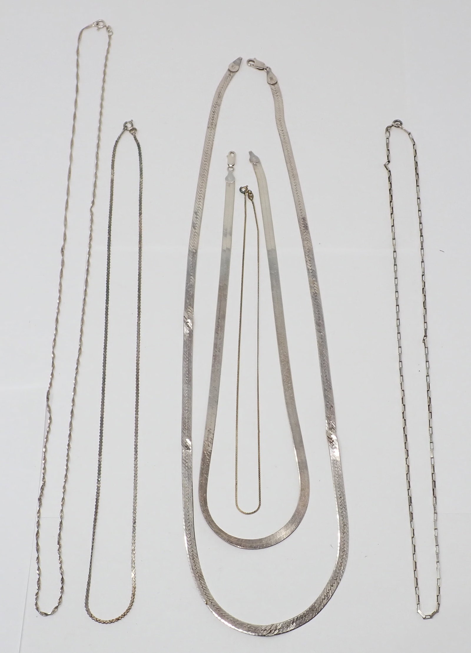 6 Sterling Chain Necklaces: Including 20" herringbone; 29" herringbone (as-is); 28" rope; 24" box link; and 24" and 16" chains. 1.811 ozt total. 29" herrabone has damage.
