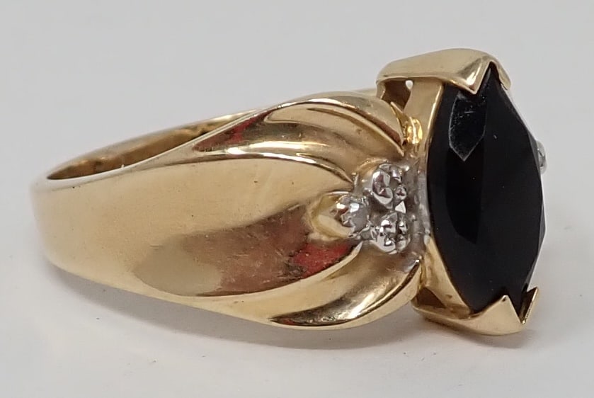 Black Onyx Ring: 14K yellow gold, marked B.J., containing a marquise cut black onyx flanked by 6 accent diamonds, ring size 10, 3.13 dwt