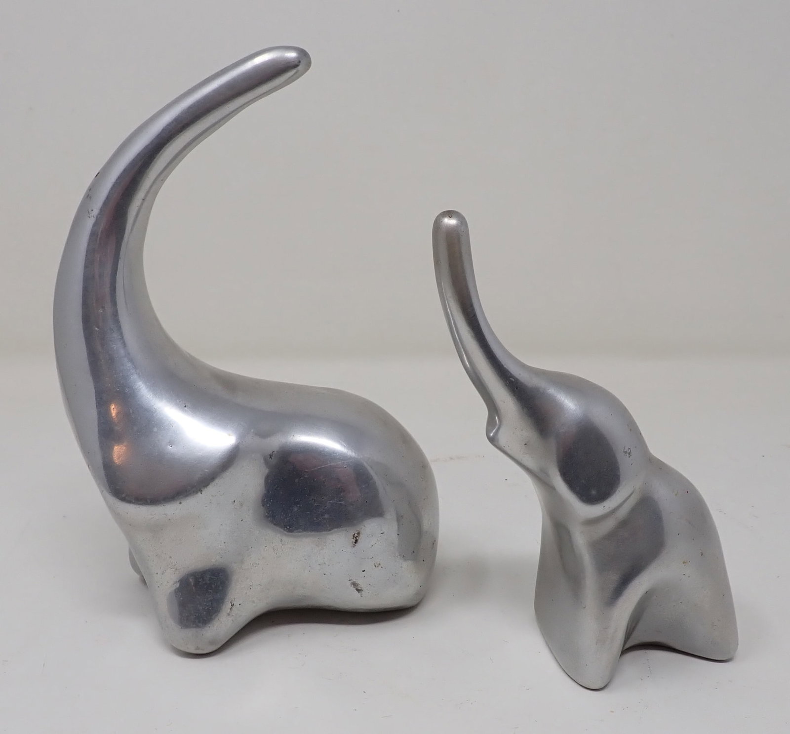 2 Hoselton Elephant Sculptures: Tallest is approx 7". Seem to be made out of stainless. Sold as pictured, with no guarantees