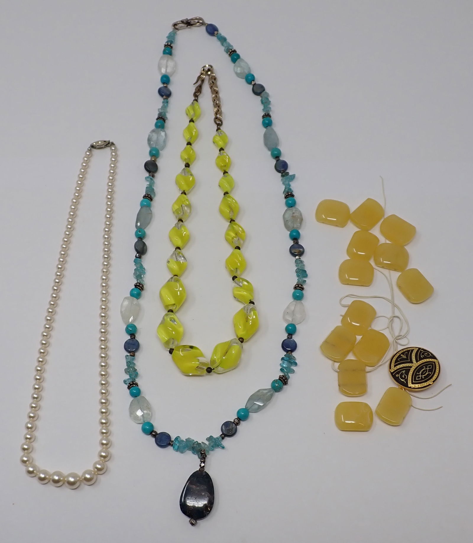 Costume Necklaces and Beads: Includes a yellow lucite beaded necklace; faux pearl necklace; turquoise and quartz beaded necklace and a grouping of yellow plastic beads.