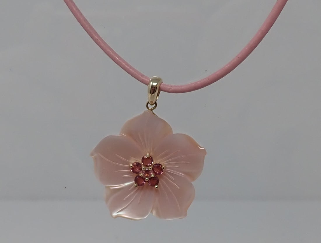 Gold and Mother of Pearl Pendant on Cord: Pink mother of pearl carved flower with 6 center pink faceted glass stones, 14K yellow gold bail marked Mexico, supported by what appears to be a pink leather cord, 17", 14K yellow gold clasp