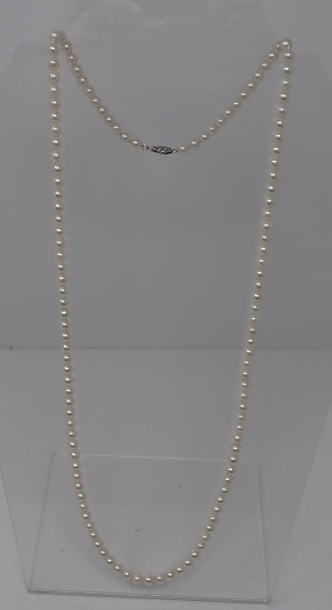 Strand of Pearls: 14K white gold filigree clasp on a 28" strand of unknotted 5mm pearls. Housed in a Miadora velvet box.