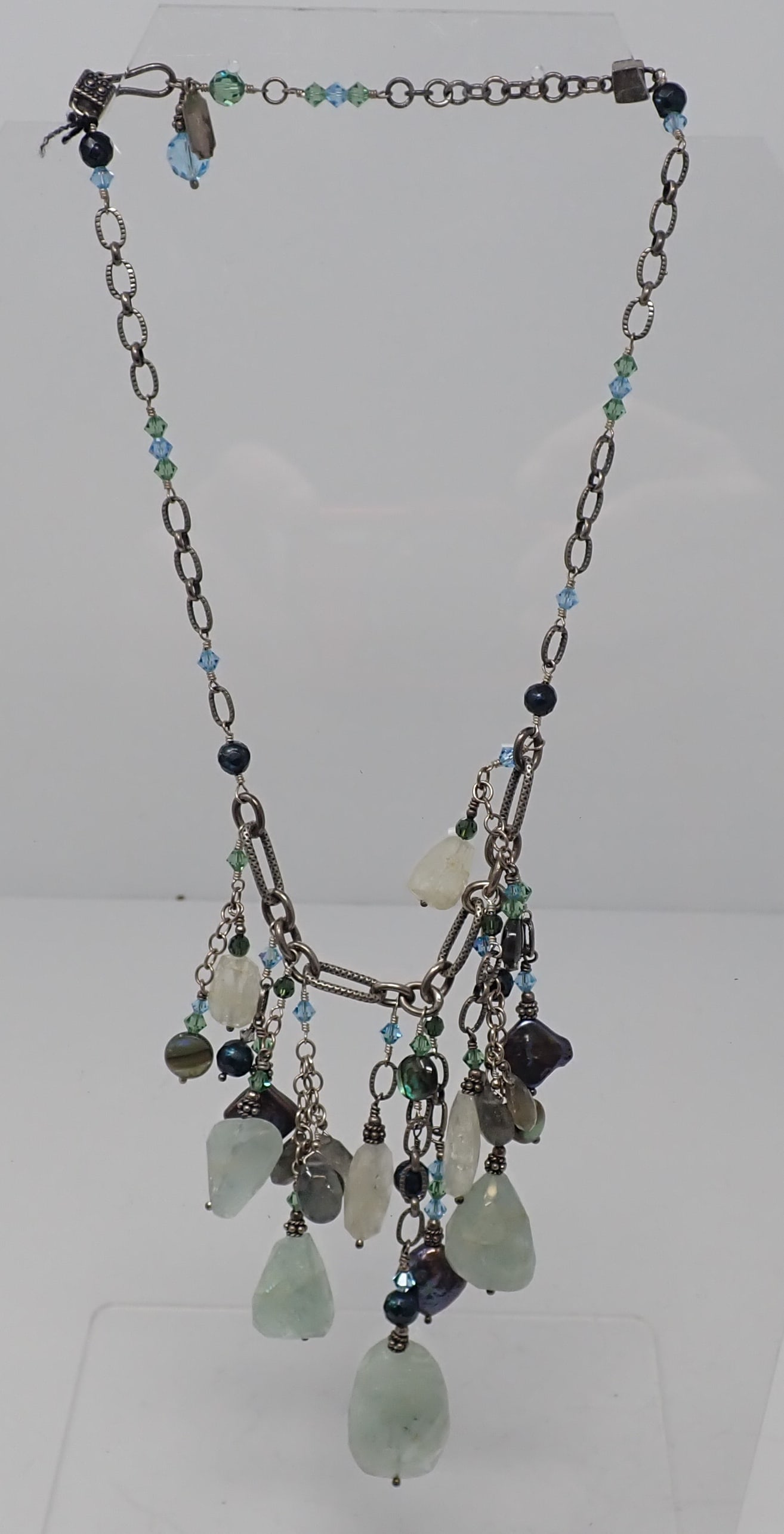 Tres Jolie Necklace: With metal plaque, silver chain with large variation of beads including green quartz, abalone, glass, labradorite and more.