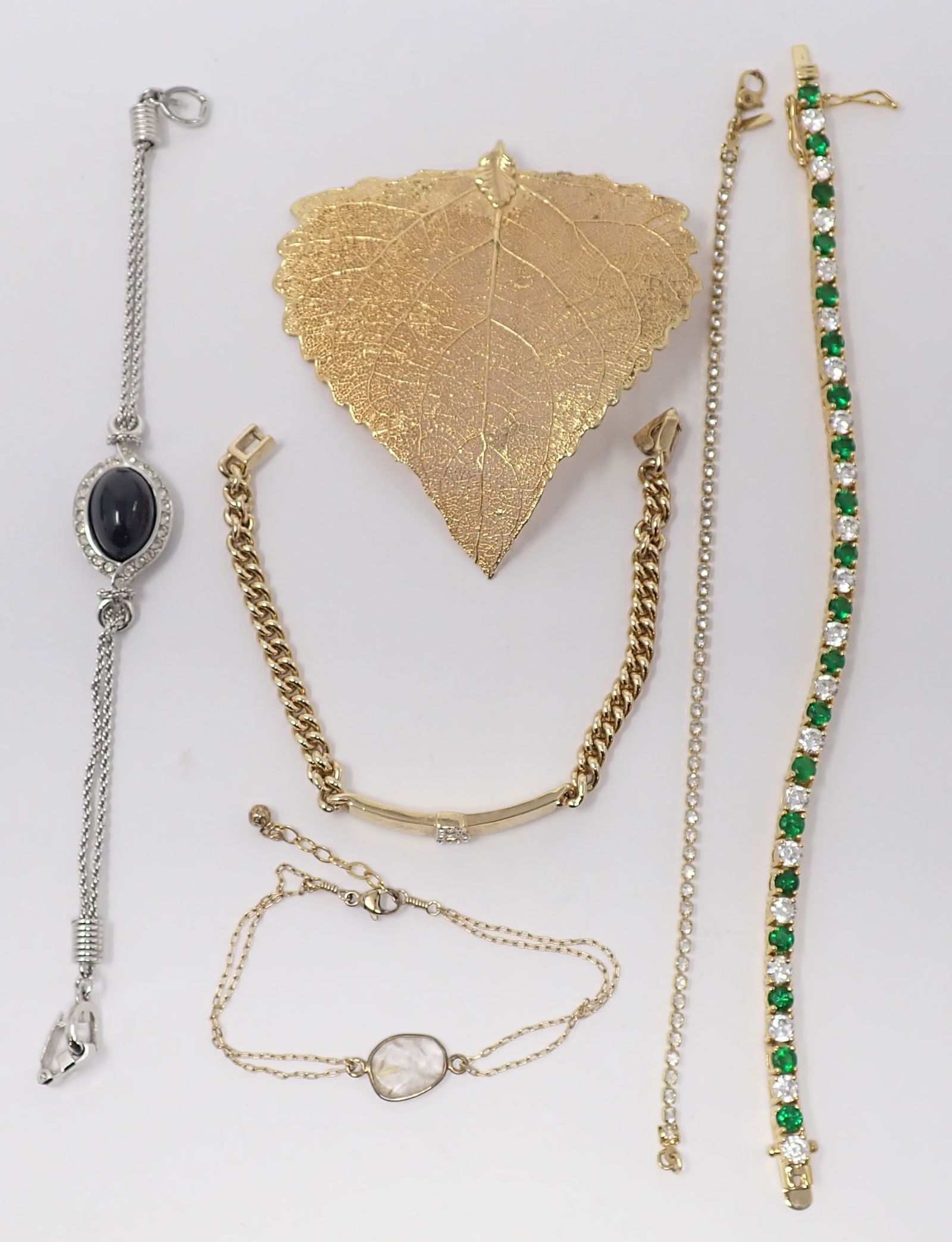 Givenchy Bracelet and Other Costume Bracelets: White gold-tone Givenchy bracelet with center black glass cabochon; gold-filled petite bracelet with quartz; 2 rhinestone tennis bracelets and other gold-tone bracelet; along with a large gold-tone le