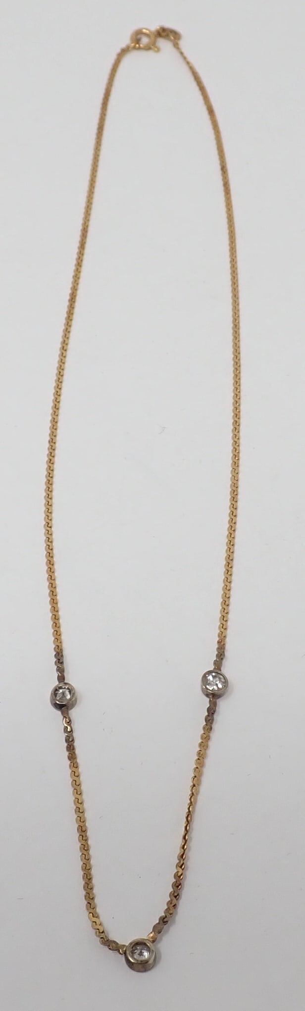 Triple Diamnd Necklace: 14K yellow gold 15" s-link chain with three bezel set full cut diamonds, approx. 0.10 ct each, 1.91 dwt