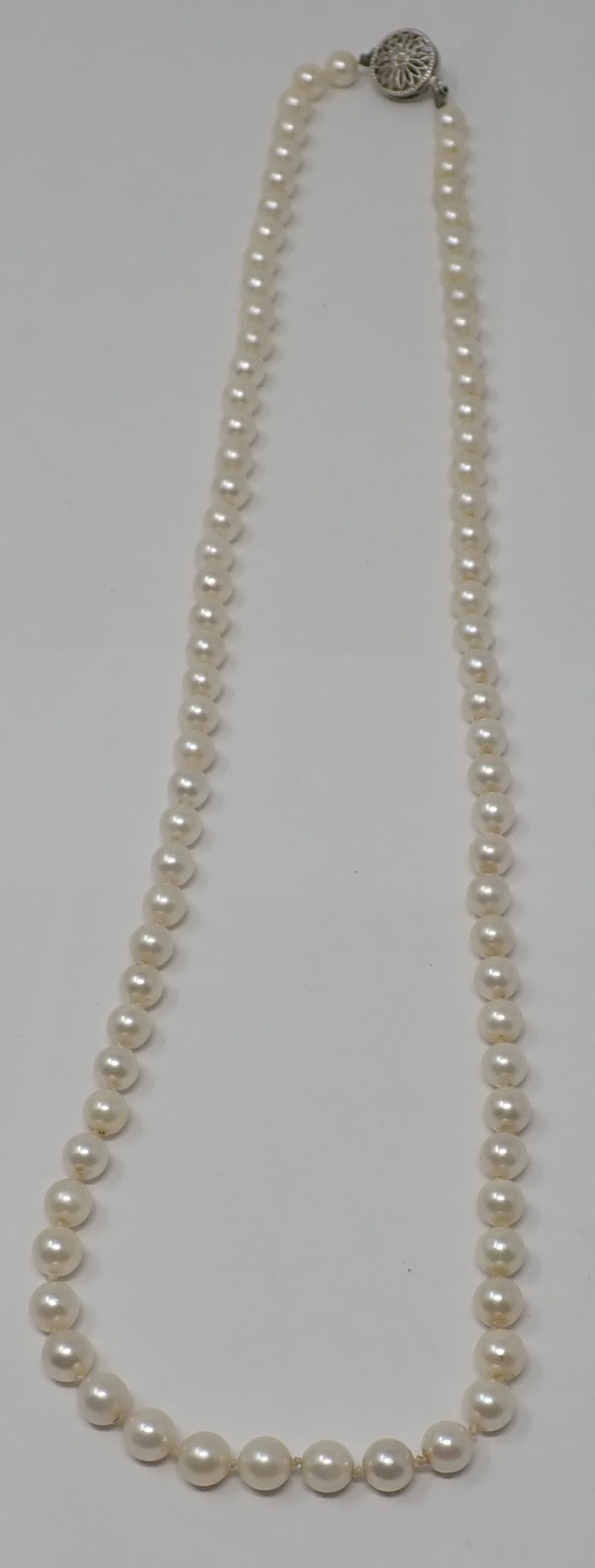 Cultured Pearl Necklace: 24" strand of 6mm cultured pearls with a 14K white gold filigree round clasp centered with a 4.5mm pearl