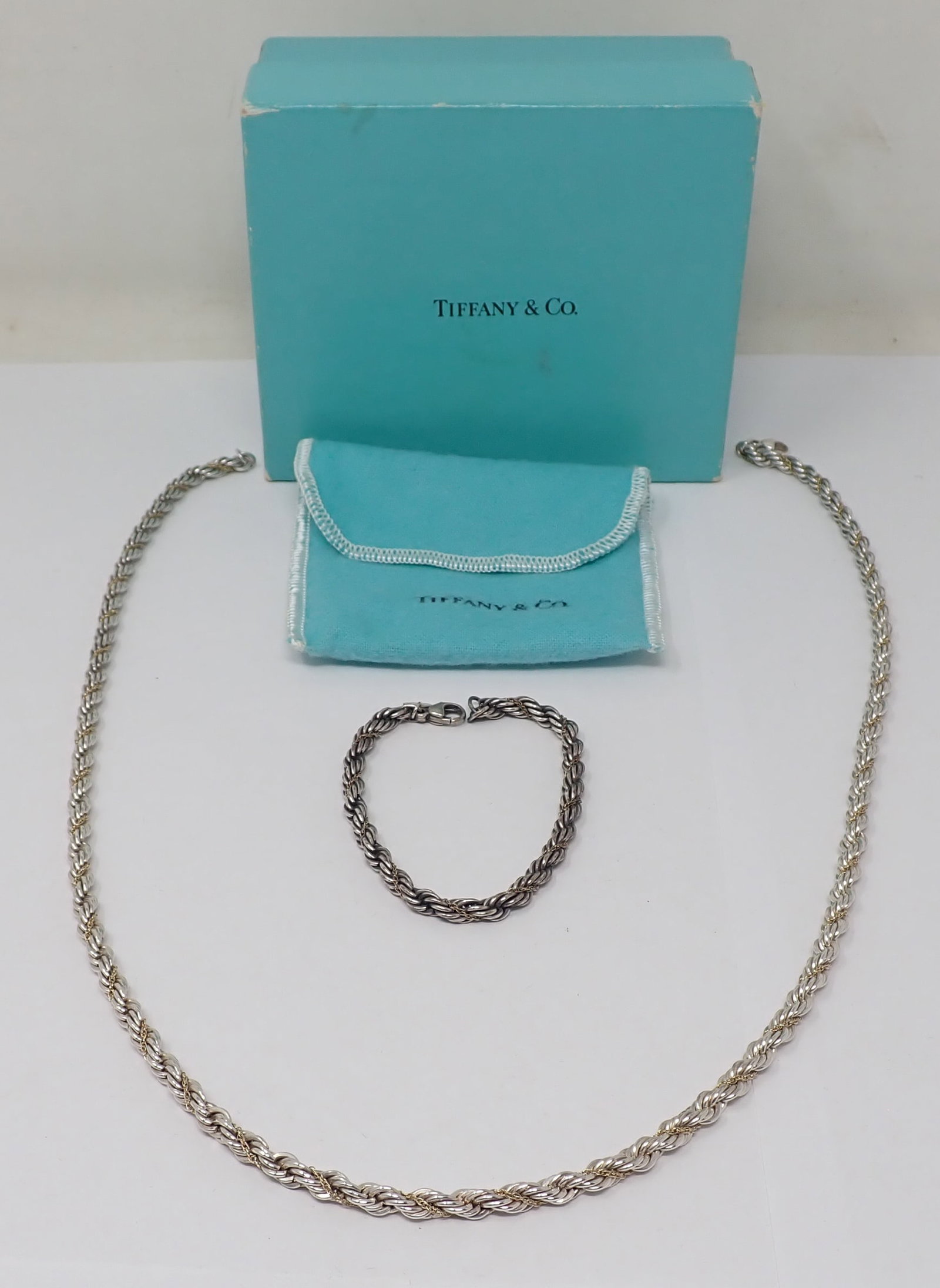 Tiffany & Co Sterling Bracelet and Necklace Set: Thick sterling rope link with gold chain accent, Necklace is 24" in length and bracelet is 7.25" length, 1.937 ozt total. With Tiffany & Co fabric pouch and box.