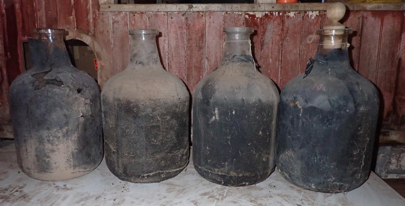 4 Glass Laboratory Bottles: Apprx 5 gallons - 10" in diameter and 20 1/4" tall. No in house shipping. Covered with a black material on outside.