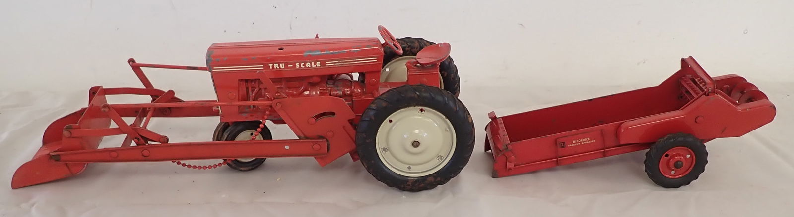 McCormick Manure Spreader & Tractor: Tractor w/ loader is approx 14" long. Does not seem like loader is on there correctly. Sold as pictured. Shipping available