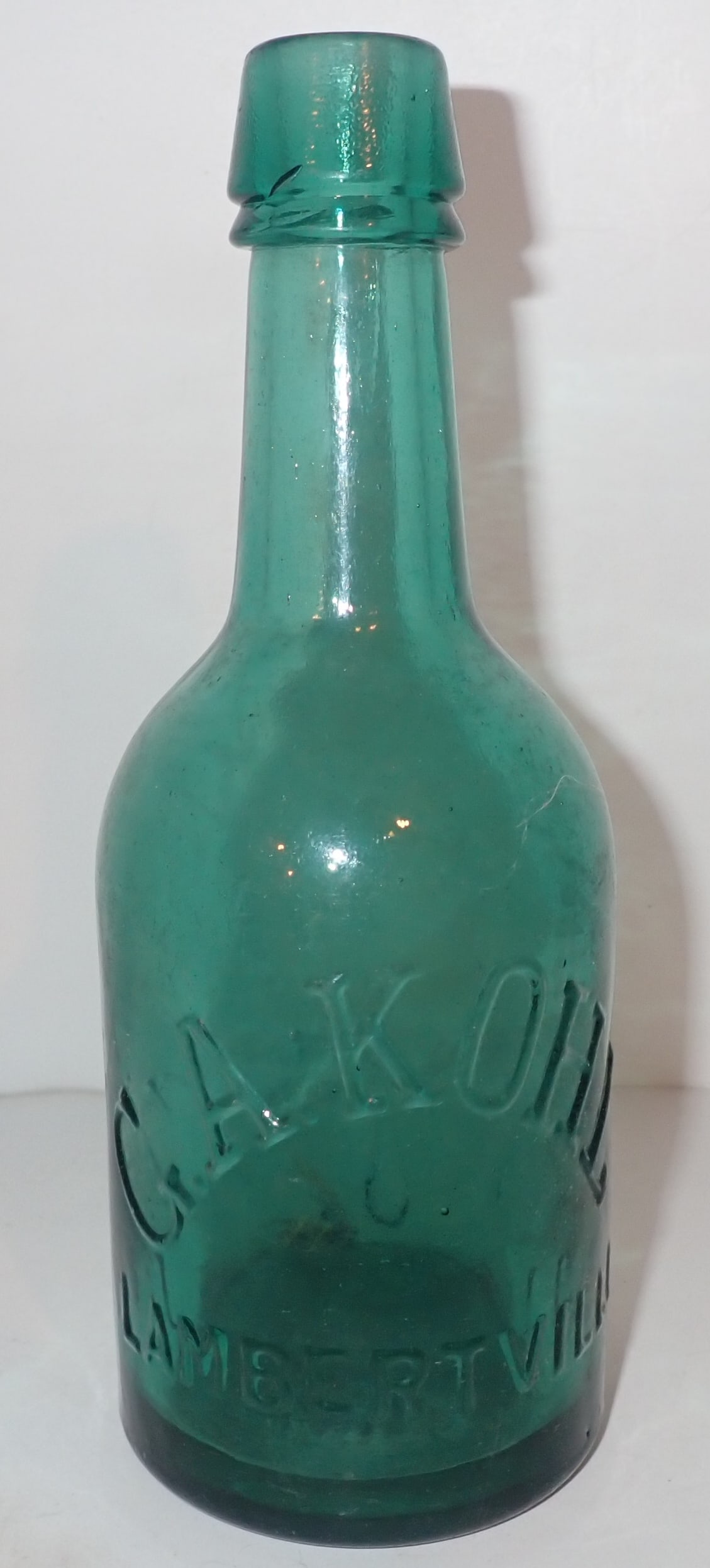 G.A. Kohl Lambertville NJ Green Embossed Bottle: Approx 2 3/4" in diameter and 7 5/8" tall. Shipping available.