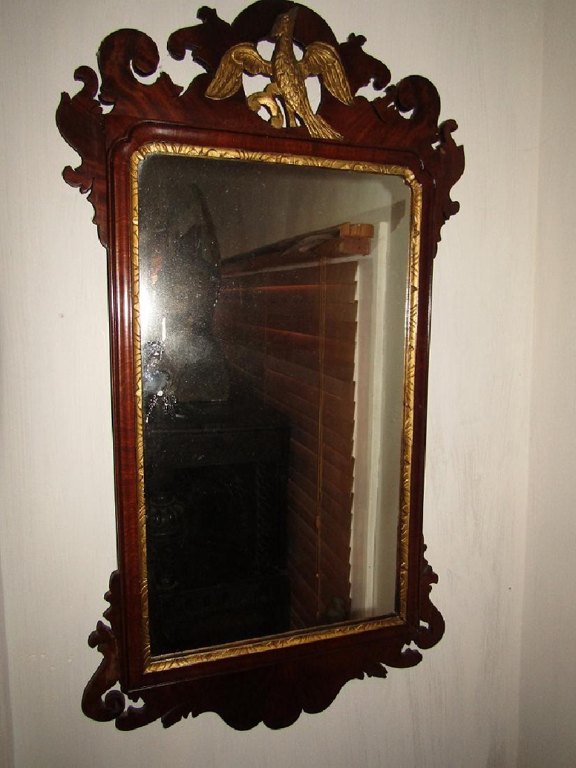 ANTIQUE MAHOGANY PHOENIX MIRROR: 18th century English mahogany Chippendale mirror with gilt phoenix bird and scrolled frame. 36 high x 20 in wide.