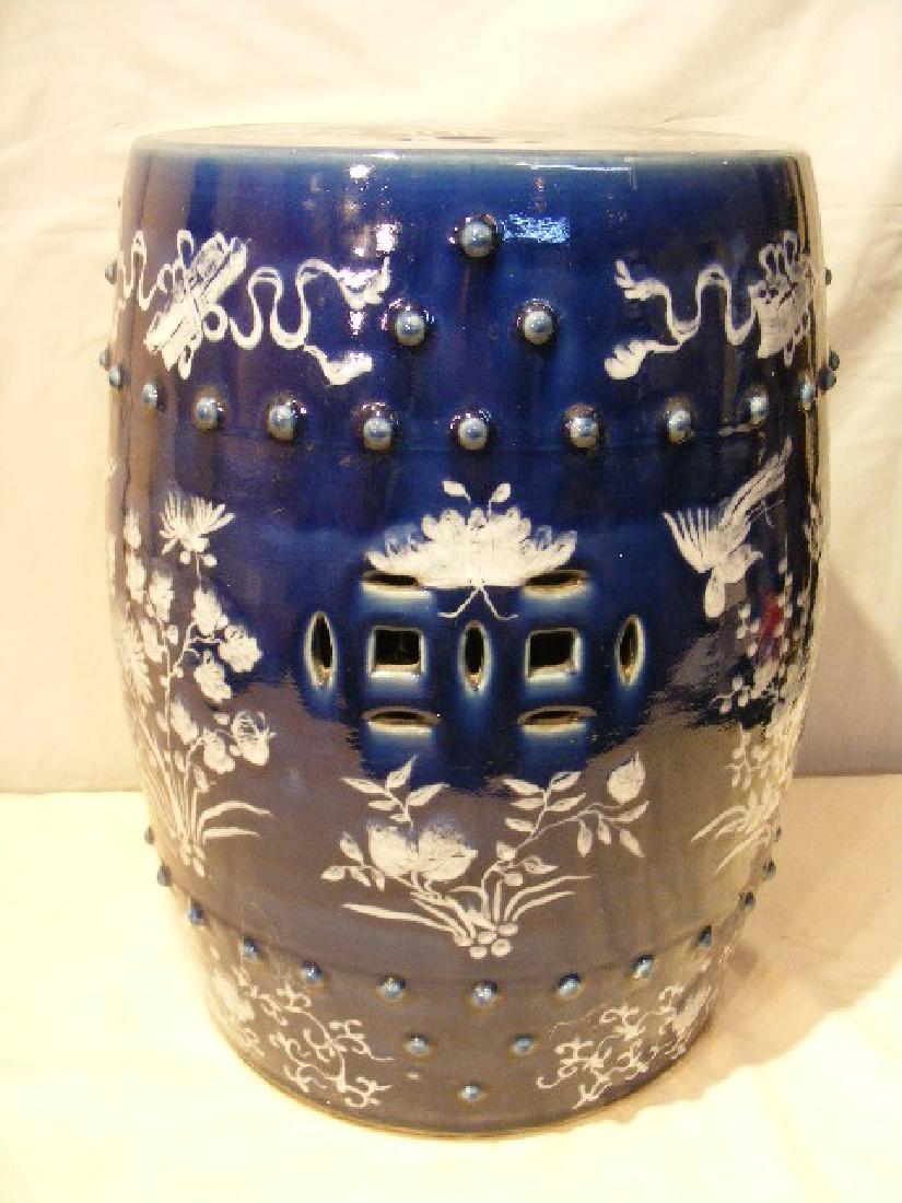 ANTIQUE CHINESE GARDEN SEAT: Antique dark blue Chinese porcelain garden seat in barrel form with reticulated designs and white florals. 19 in high x 12 in diameter. Good condition, unsigned.