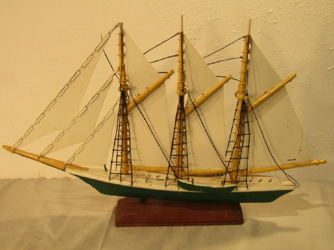 FRANK ADAMS SHIP WEATHERVANE: Old wood and metal sailboat weathervane painted green and white by Frank Adams. 29 x 16 inches plus stand.