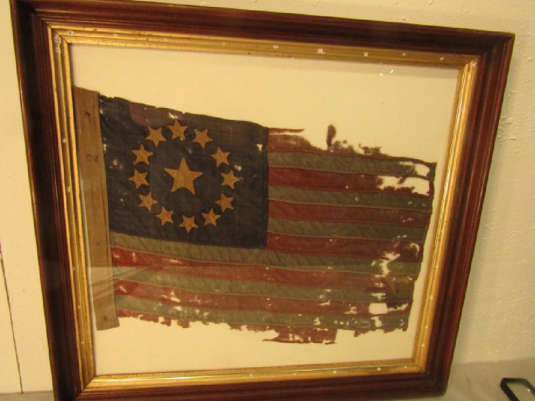 CENTENNIAL COLONIAL FLAG: 19th c. American Centennial flag with circular colonial 13 stars. Victorian walnut frame. Some holes/tears. 24 X 16, framed 29 x 27. Can be shipped w/out frame.