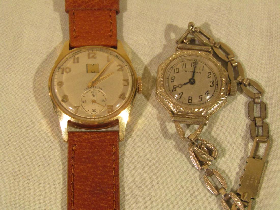 TWO 14K GOLD LADIES WATCHES: 2 ladies 14k gold wristwatches including Waltham white gold 14k, with plated bracelet; and a Lord Elgin M ladies watch with leather band, 14k gold case, 1951 Monsanto presentation. Both 1" diameter.