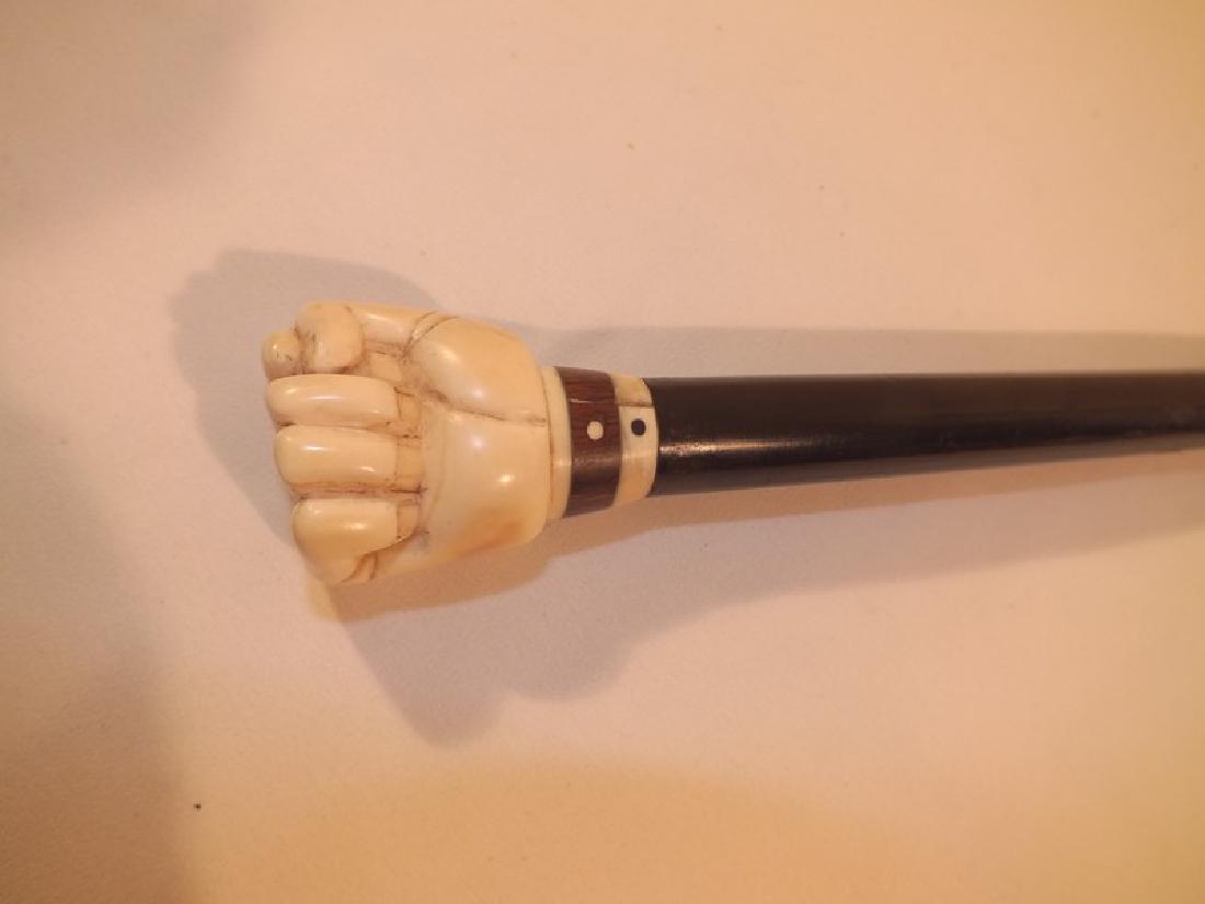 ANTIQUE BONE FIST CANE: Carved bone clenched fist cane with rosewood and ebony shaft, tight crack on handle. 36 inches long.