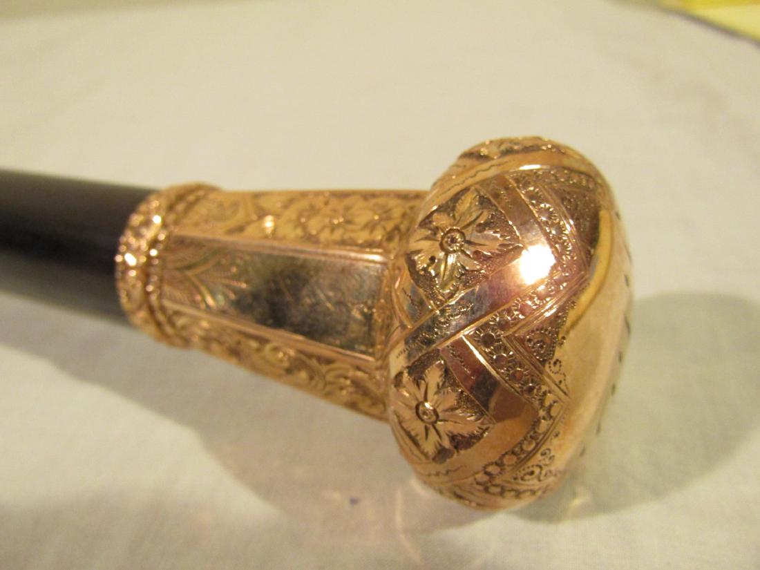 ANTIQUE FANCY GOLD DRESS CANE: Gold filled fancy dress cane with ebony shaft and floral embossed designs. Has lion head hallmark and stamped Lyon Maker. Monogrammed, 36 inches long