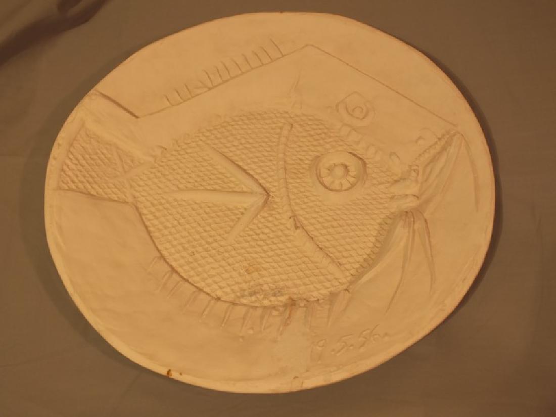 PICASSO 1956 FISH CHARGER: Plaster wall charger of a tropical fish signed Picasso 19.5.56 and R=C100. Size: 16.5 in diameter. Condition: appears there may be a repair to about 3 in crack from rim toward center and some scattere