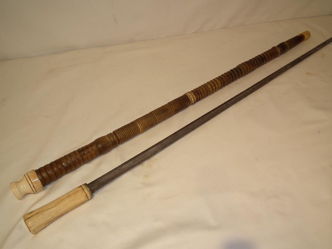SUPERB 19TH C. SWORD CANE: Fine 19th century sword cane with carved horn segments along shaft. Blade is vg condition 32 inches long, overall 38 inches. Some minor loss/damage to horn, replaced collar on scabbard.