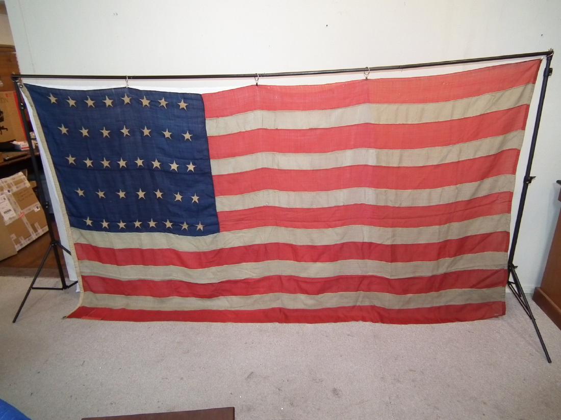 LARGE 38 STAR AMERICAN FLAG: Large 38 star American flag, appears hand stitched, 117 inches x 68 inches, Circa 1877. Stenciled E. LANNIN NY, 10X, also hand marked GATB. Has patch repair.