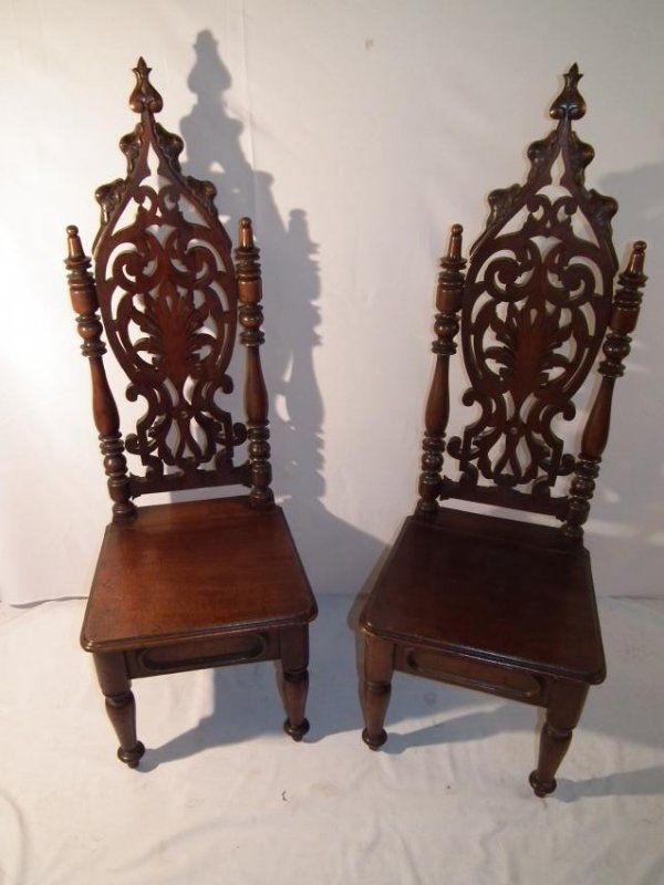 PAIR GOTHIC VICTORIAN CHAIRS: Pair of Victorian Gothic Revival carved walnut tall back chairs with lift top seats. 51 in high x 17.5 in square.