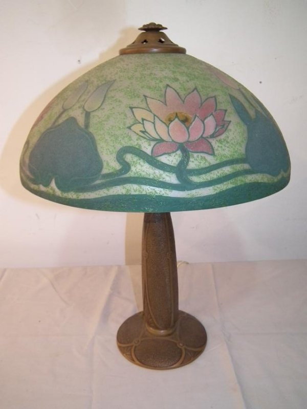 MILLER ARTS & CRAFTS PAINTED TABLE LAMP: Antique patinated metal Arts and Crafts table lamp signed Miller 828 on underside. 16.5 inch painted glass shade with water lillies and pink flowers. 22 in tall. Exc. Condition.