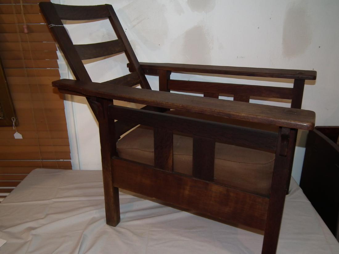 LIMBERTS OAK MORRIS CHAIR: Antique oak paddle arm Morris chair with double vertical slats and horizontal slat under arms. 36.5 in deep x 29.5 in wide.