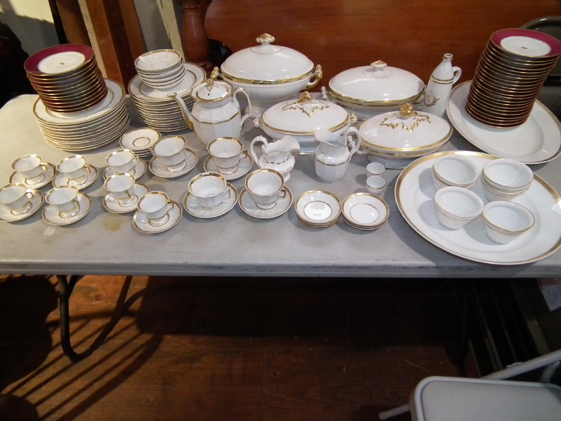 PARIS PORCELAIN DINNER SET: Extensive set of 19th century Paris porcelain and Limoges white and gold dinnerware as displayed with about 75 pieces including 9 serving pieces; plus 34 porcelain salad plates with maroon rim and cro