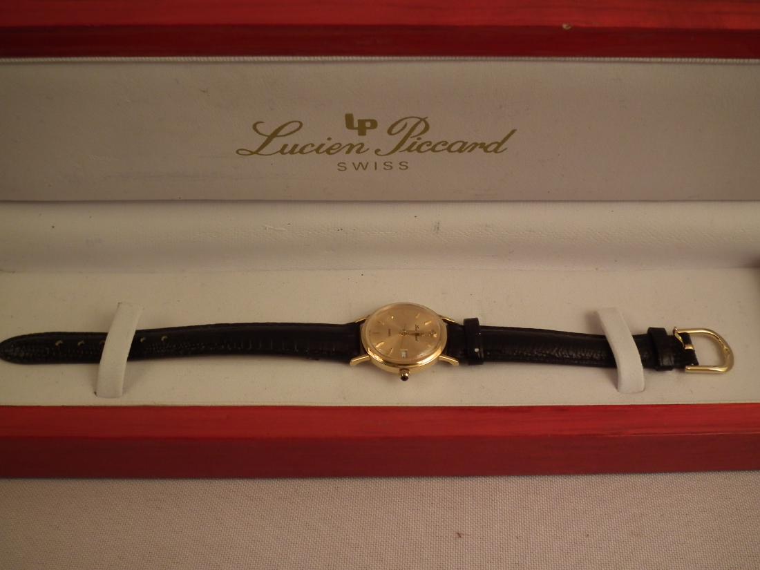 PICCARD 14K WATCH: Ladies Swiss quartz wristwatch by Lucien Piccard with 14k gold one-inch case dated '06 with diamond dial and date box. Black leather band in original box. 7.5 in long.