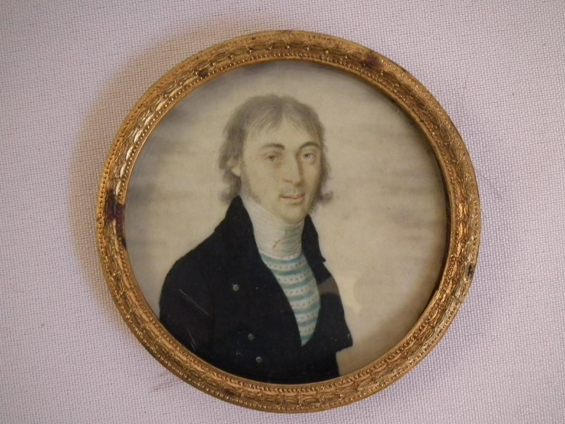 MINIATURE PAINTING OF A SHIP CAPTAIN: Fine round painting of a ship captain wearing blue striped shirt and navy pea coat. In brass frame with woven hair memorial back. Size: 2.5 inches diameter.