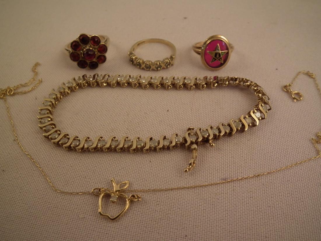 5 PCS GOLD JEWELRY: Lot 5 pieces gold jewelry including: 10k diamond tennis bracelet, 7 in long; 10k ring with star; 10k garnet ring; 10k diamond X ring. 12 dwt. Plus thin apple necklace ##