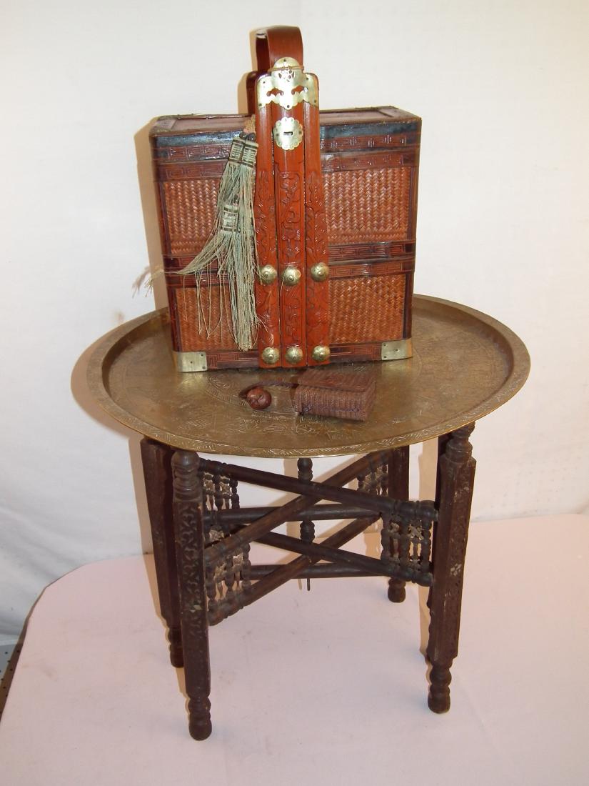 ASIAN INRO & TABLE & BASKET: Lot of Asian items including: Middle Eastern wood folding table with Egyptian engraved brass charger top, 23 inch round; carved wood Japanese Inro box with skulls; Asian woven bride's basket.