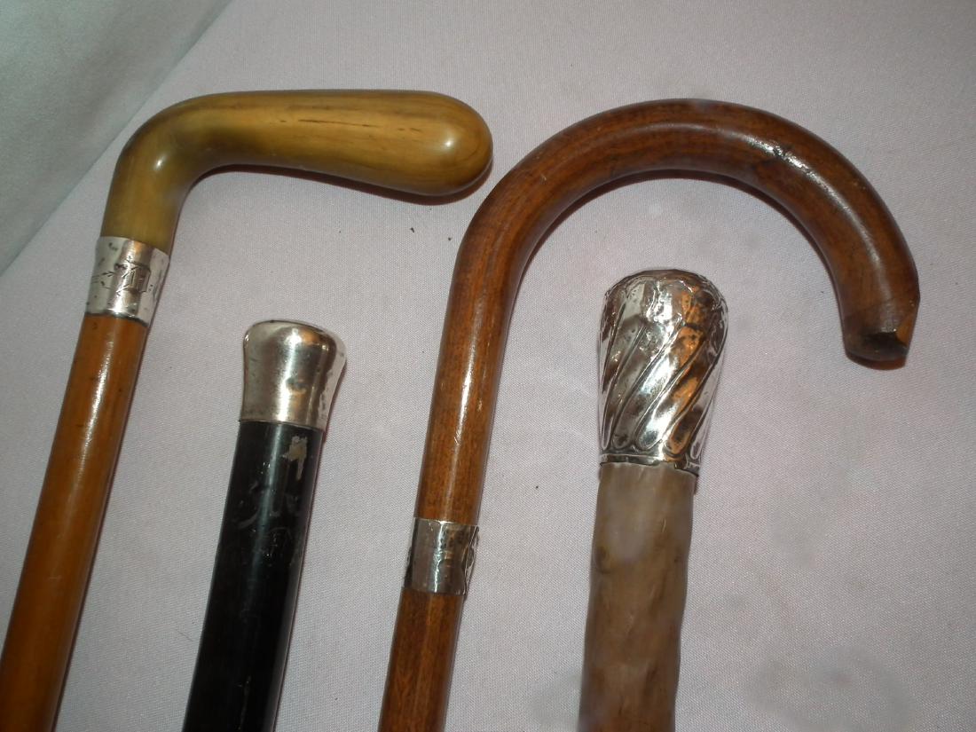 4 ASSORTED CANES: Lot 4 old canes with silver tips or collars including: 1916 stag handled initialed; English sterling with hallmarks (dents); ebony and curved handle. To 36 inches.