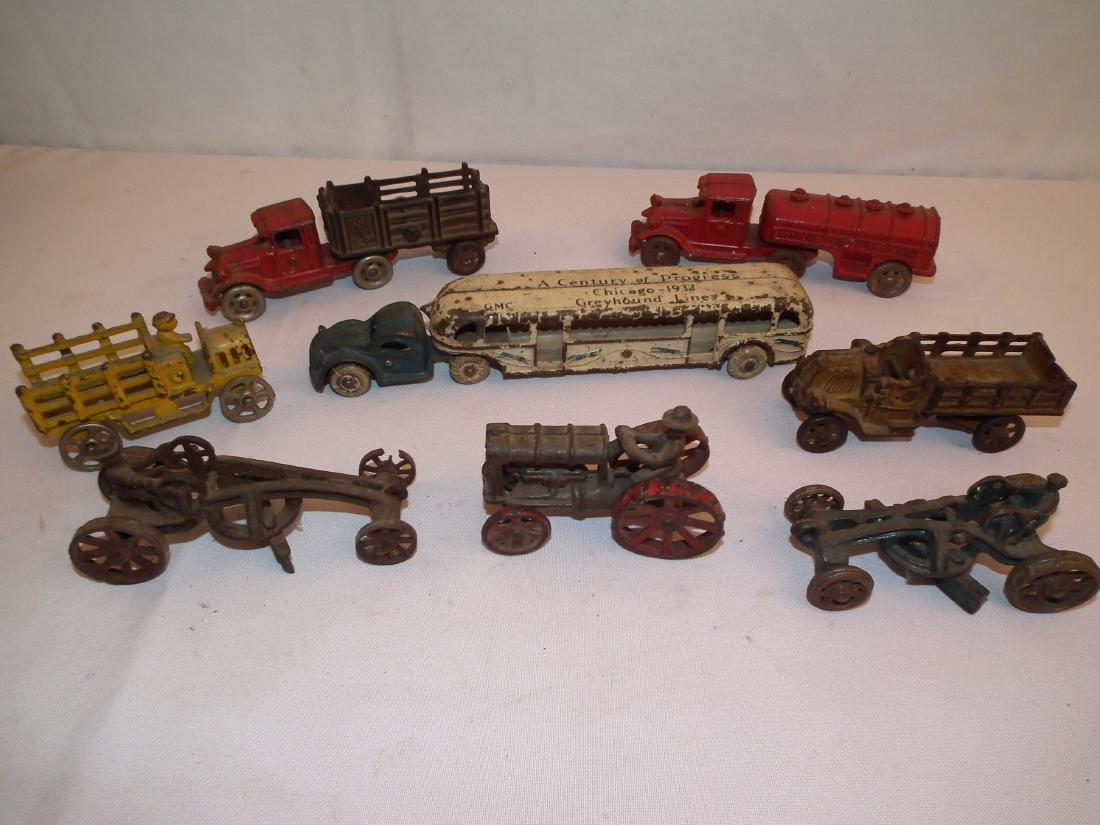 8 ANTIQUE VEHICLES: Lot of 8 antique iron toy vehicles including 1933 GMC Greyhound bus by Arcade, 10 inches; 7 inch truck stamped C to C C. Co. on side; red gasoline truck, 7 inches; 3 farm tractors. All unsigned.