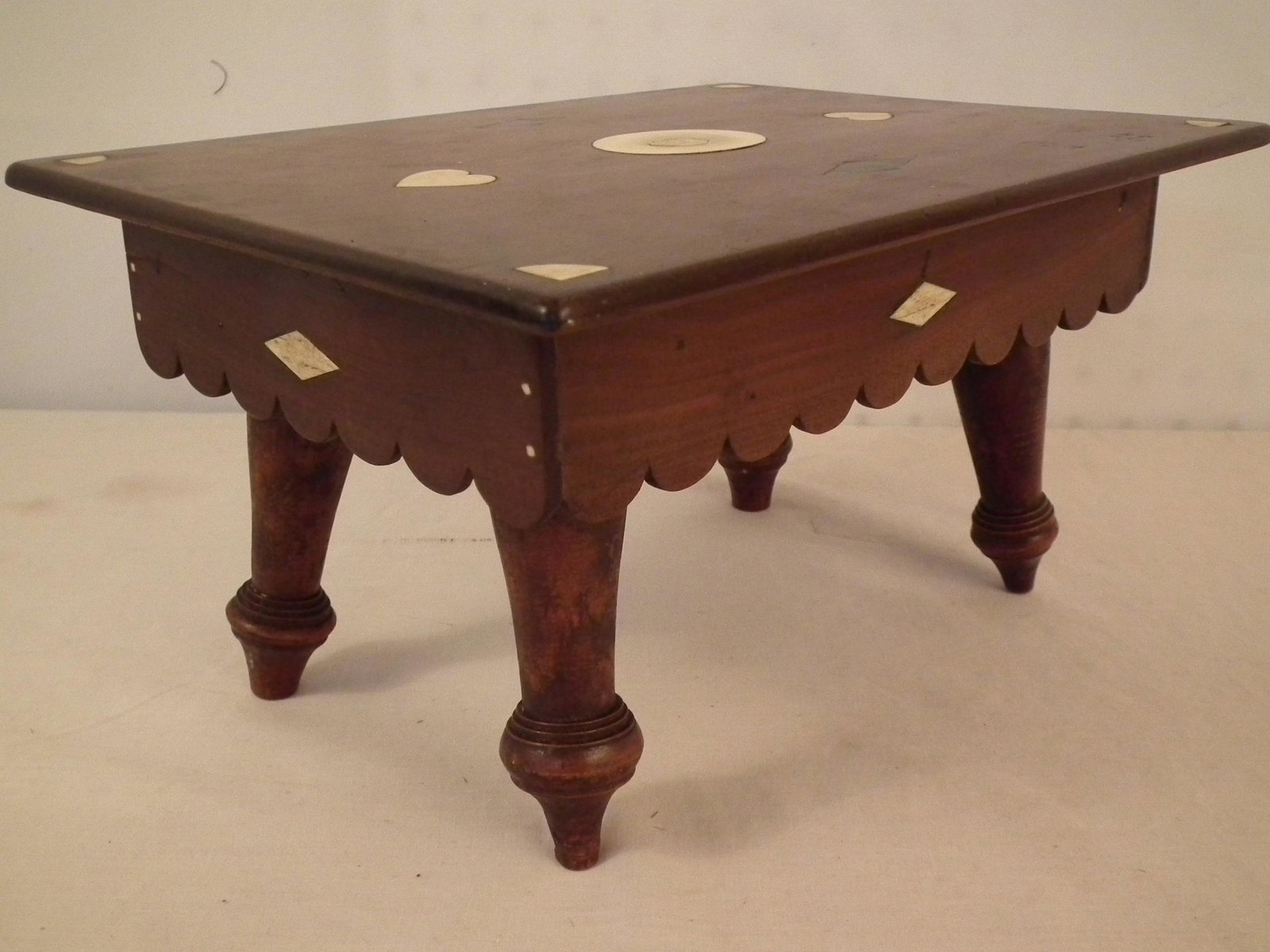 SAILOR MADE FOOTSTOOL: Fine 19th century sailor-made mahogany footstool with scalloped apron and inlaid bone geometric designs. 12 x 9 x 6.5 inches high.
