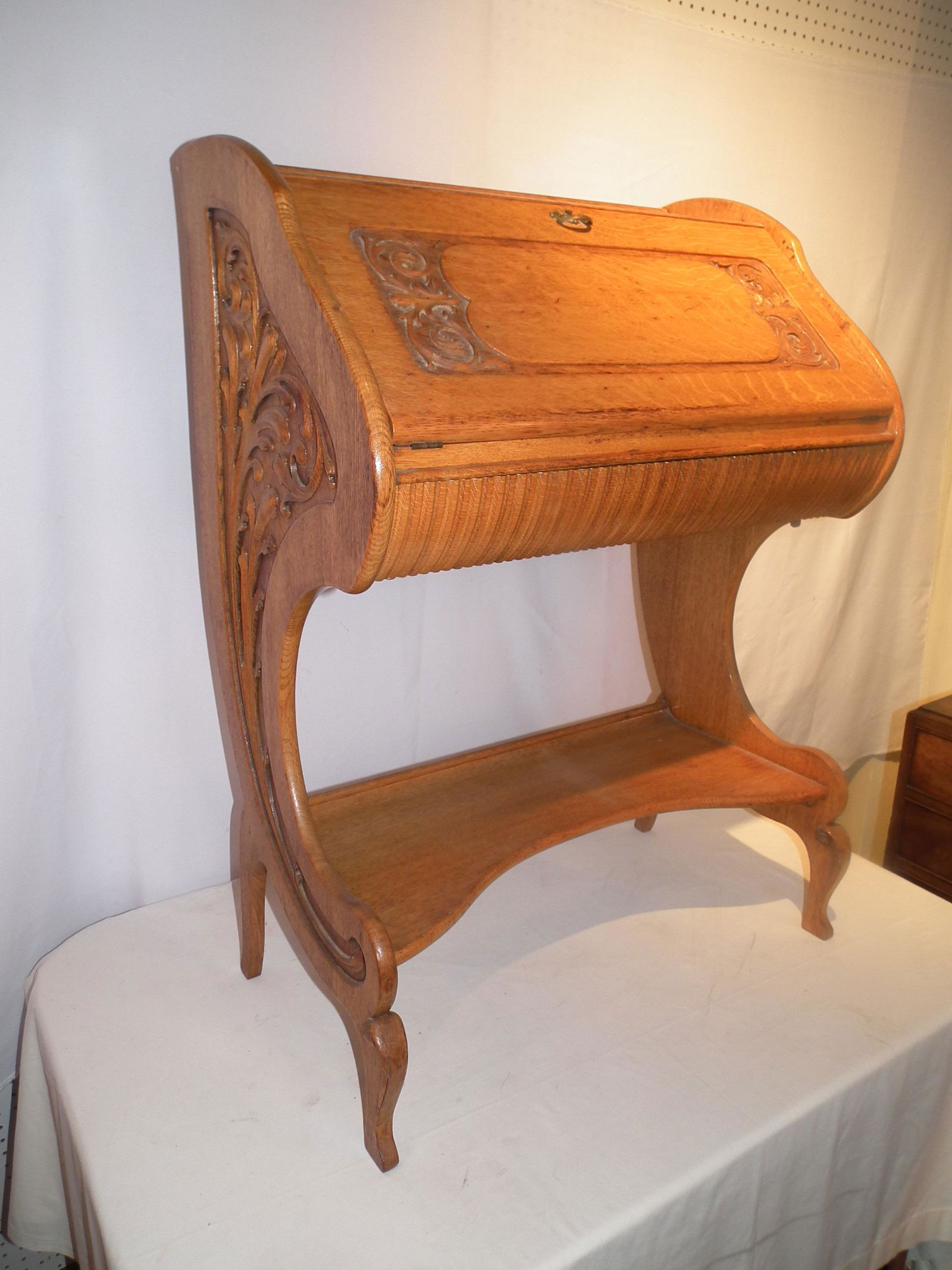 ART NOUVEAU OAK DESK: Unusual and graceful Art Nouveau solid oak ladies slant lid desk with deeply carved arabesque designs. 40 high x 29 x 17 inches.