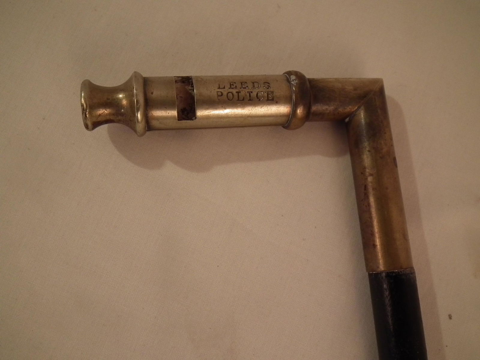 LEEDS POLICE WHISTLE CANE: Antique whistle cane with ebony shaft and brass handle engraved with "Leeds Police", 36.5 inches long.