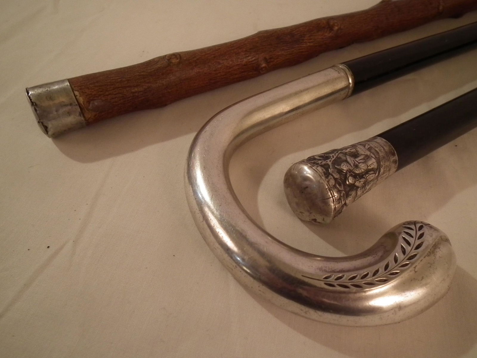 3 SILVER TOP CANES: Lot 3 silver topped canes: shepherd hook stamped Alpacca w/ebony shaft; Asian genre w/ebony shaft; knobby shaft with carved alligator; and silver knob cane with date 1891 and initials. To 35 inches lo