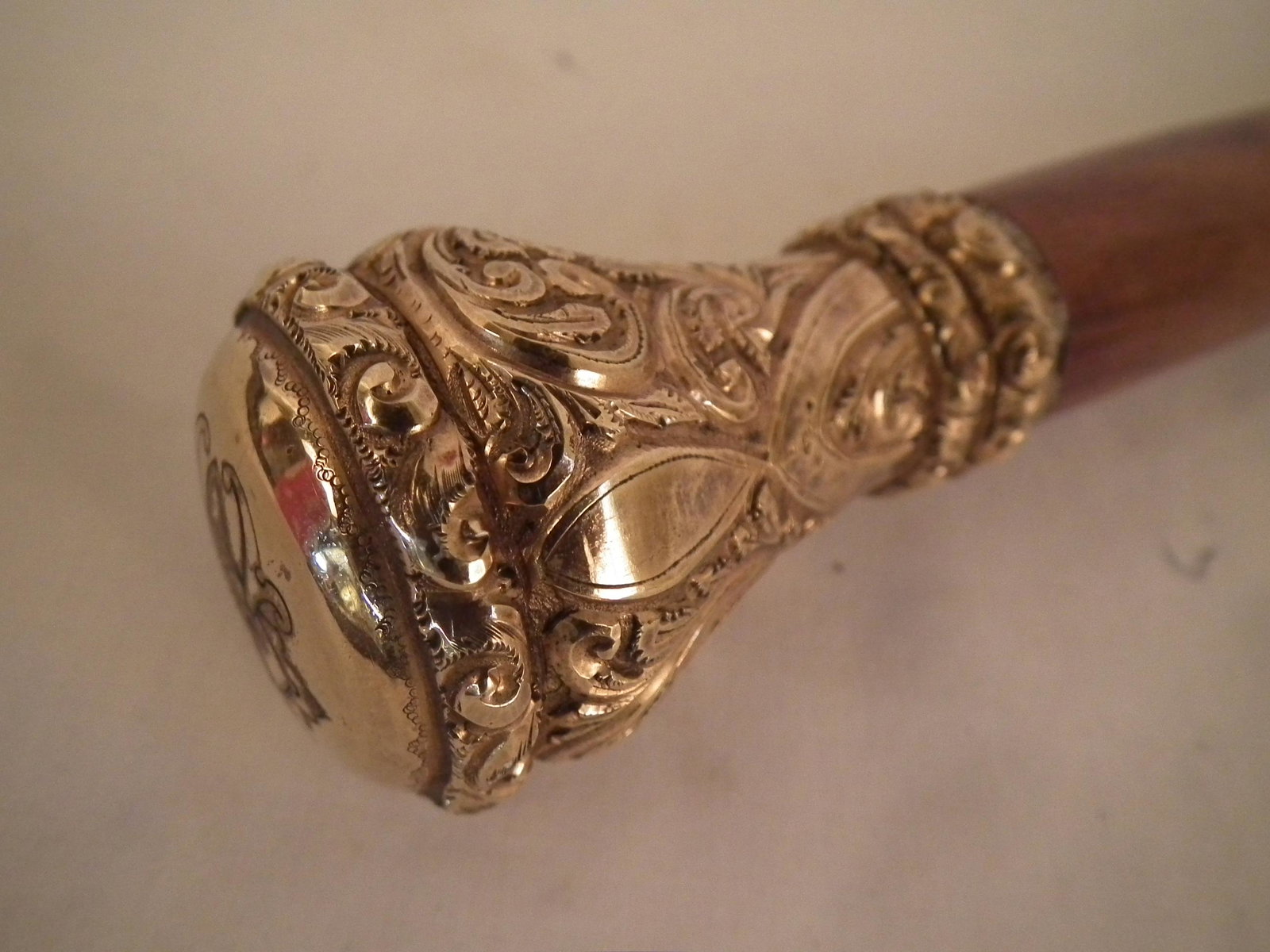 FANCY GOLD FILLED CANE: Fine gold filled can with fancy chased knob having a cross and 17P hallmark, gold spacers, and ferrule. 35.5 inches long.