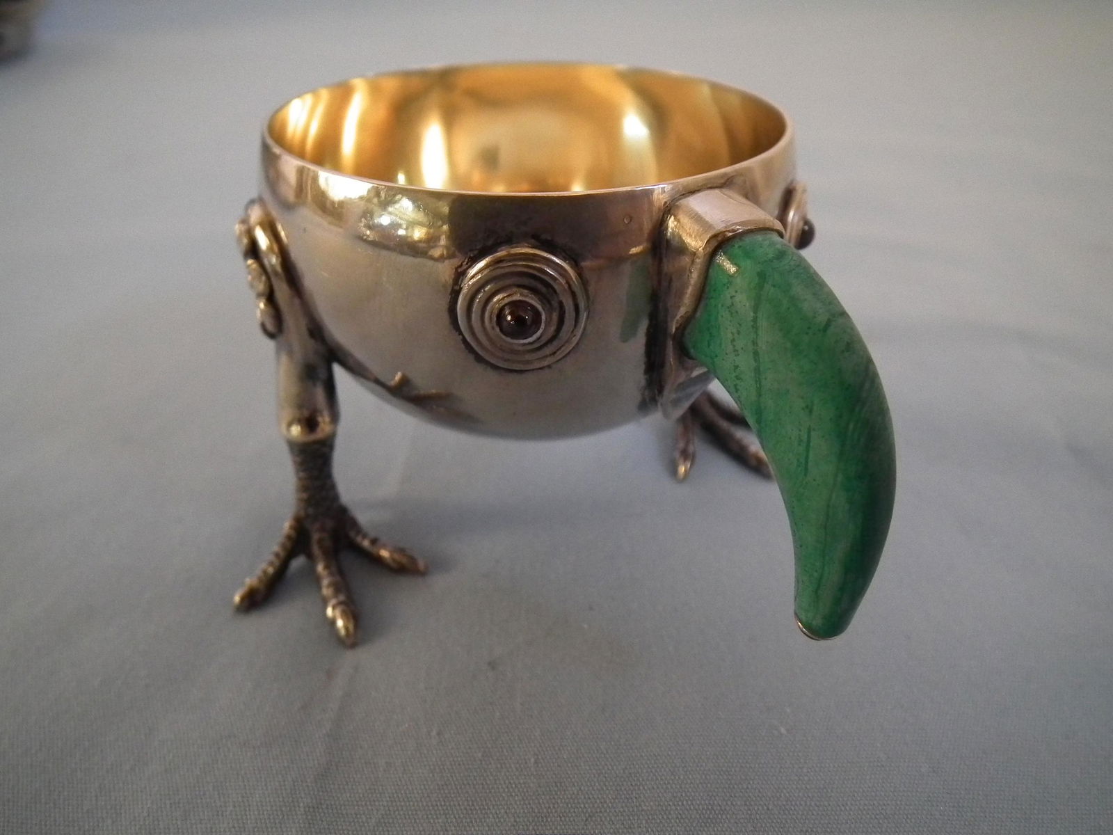RUSSIAN EGG HOLDER: Whimsical Russian silver egg holder or master salt in the form of a bird with malachite beak & ruby tip, claw feet, ruby eyes, gilt interior. Stamped 88 silver standard and 20A. 1.97 ozt. 3 in long x
