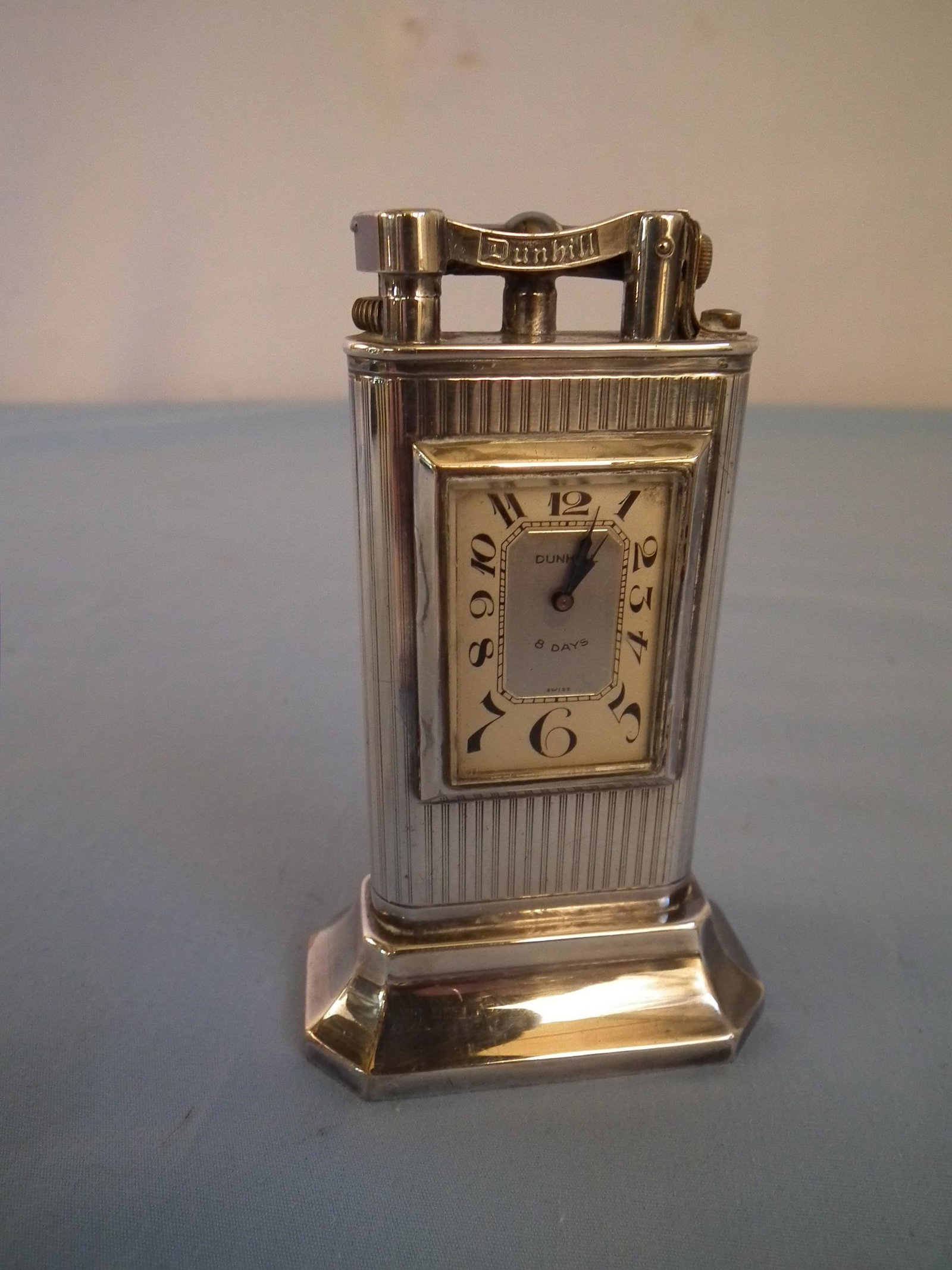 DUNHILL LIGHTER WATCH: Old silver plated Dunhill lighter watch with Swiss 8 day movement, Dunhill Unique model, 1.25 in dial. Appears to be working, lighter untested. 6.2 ozt.