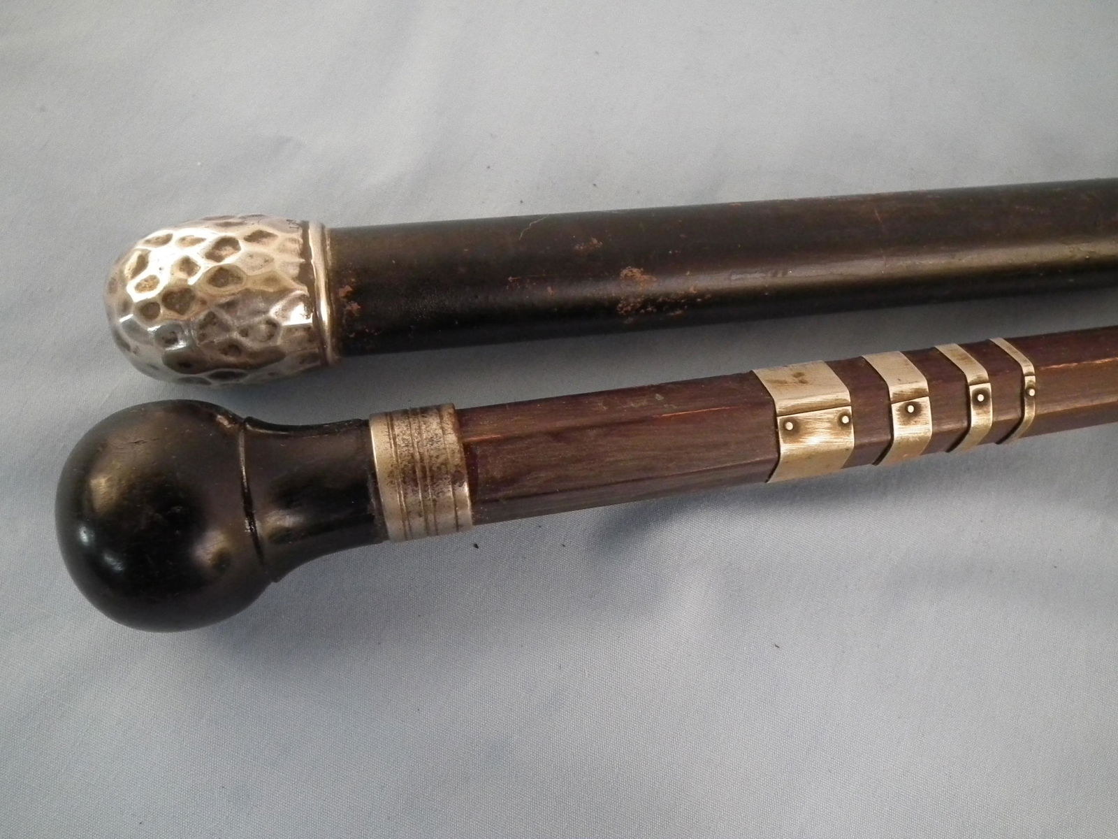 2 ANTIQUE CANES: Lot of 2 canes with silver mounts including: hammered silver knob stamped 138T, 35 inches; and ebony knob with silver plated collars, 32 inches.
