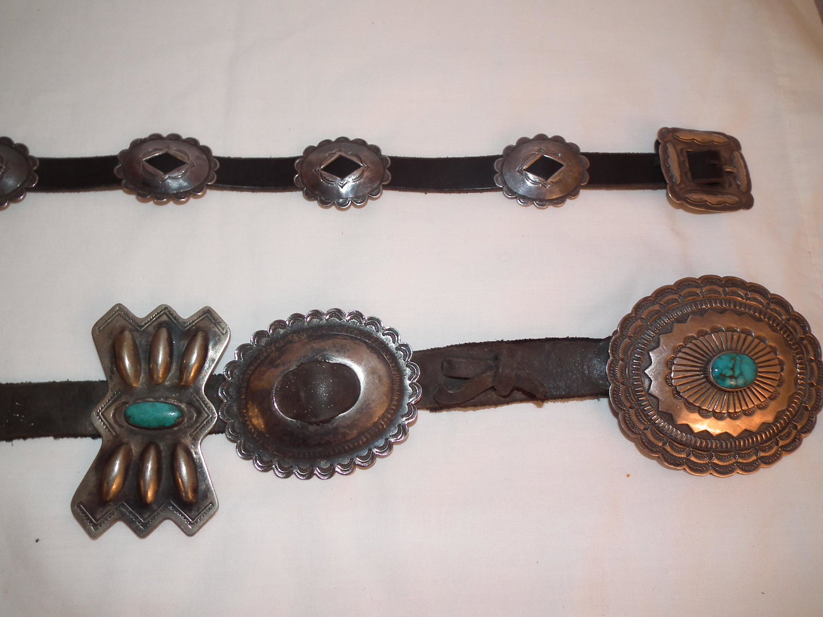 2 NAVAJO SILVER CONCHA BELTS: 2 Navajo pawn leather belts with silver conchas with turquoise inlays (3 inch and 1.5 inch). Womans belt has 13 disks and mens has 11. Stamped R. MARTINEZ.