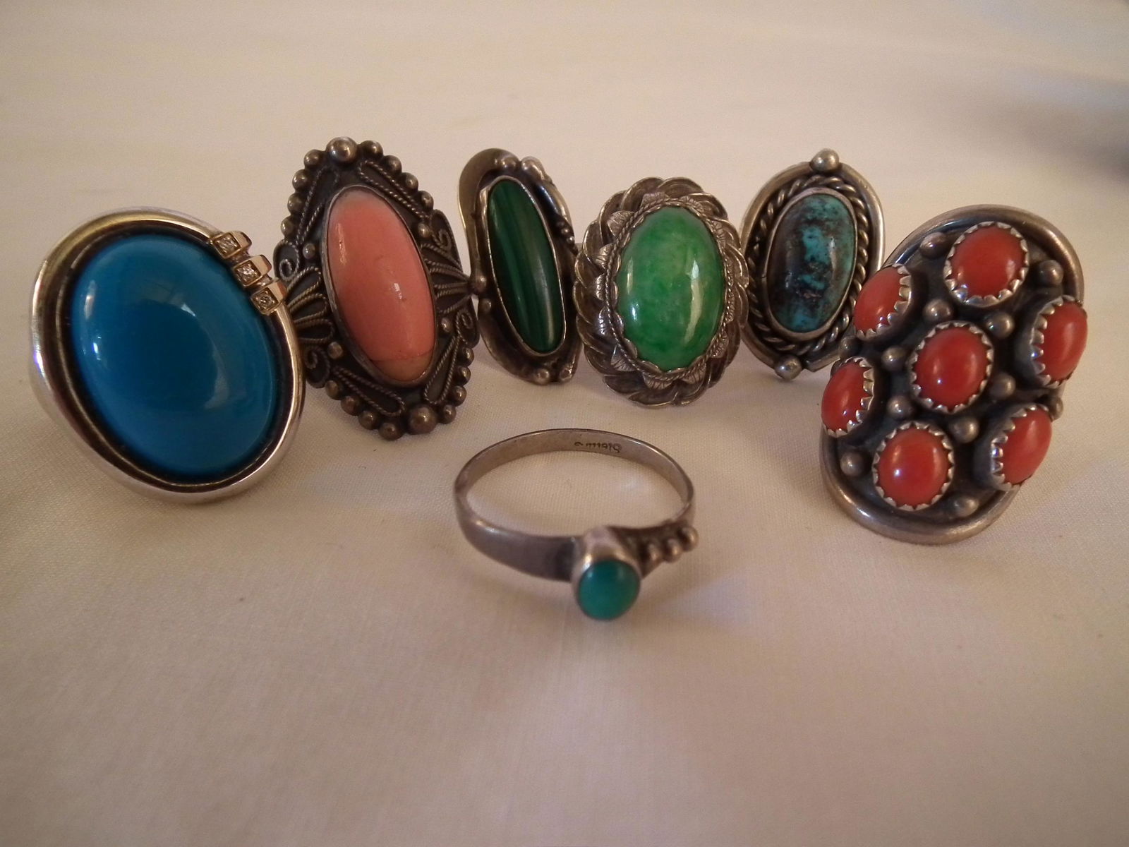 7 NAVAJO GEM RINGS: Lot of 7 Navajo sterling silver Soutwestern rings with inlaid stones. Weight 57.2 grams