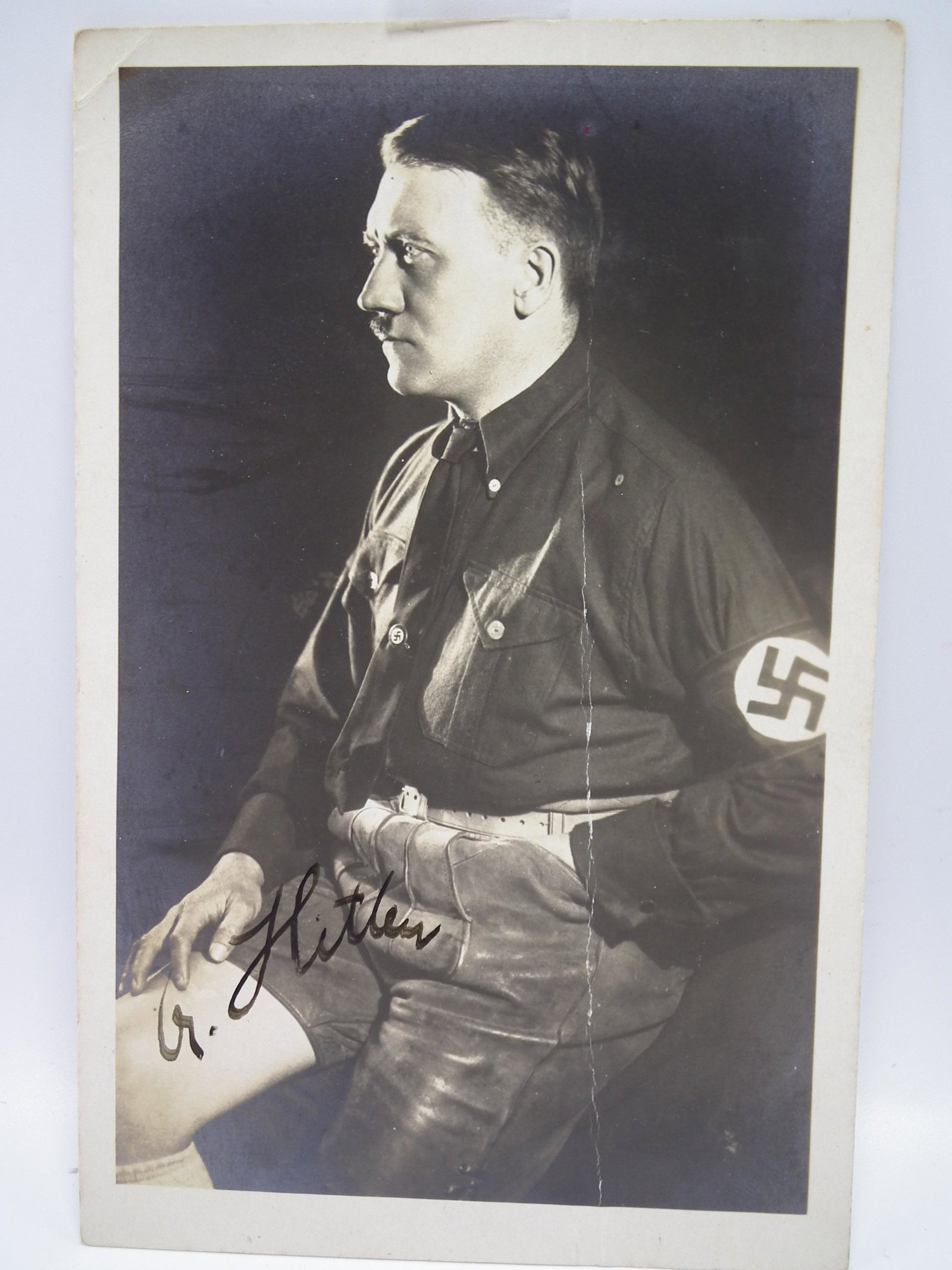 ADOLF HITLER SIGNED PHOTO: Authentic black and white photograph of Adolf Hitler in Nazi party shirt and (rare) leather shorts. Signed in ink A. HITLER. Size: 5.5 x 3.5 inches. Good condition with vertical crease. Modern frame. 