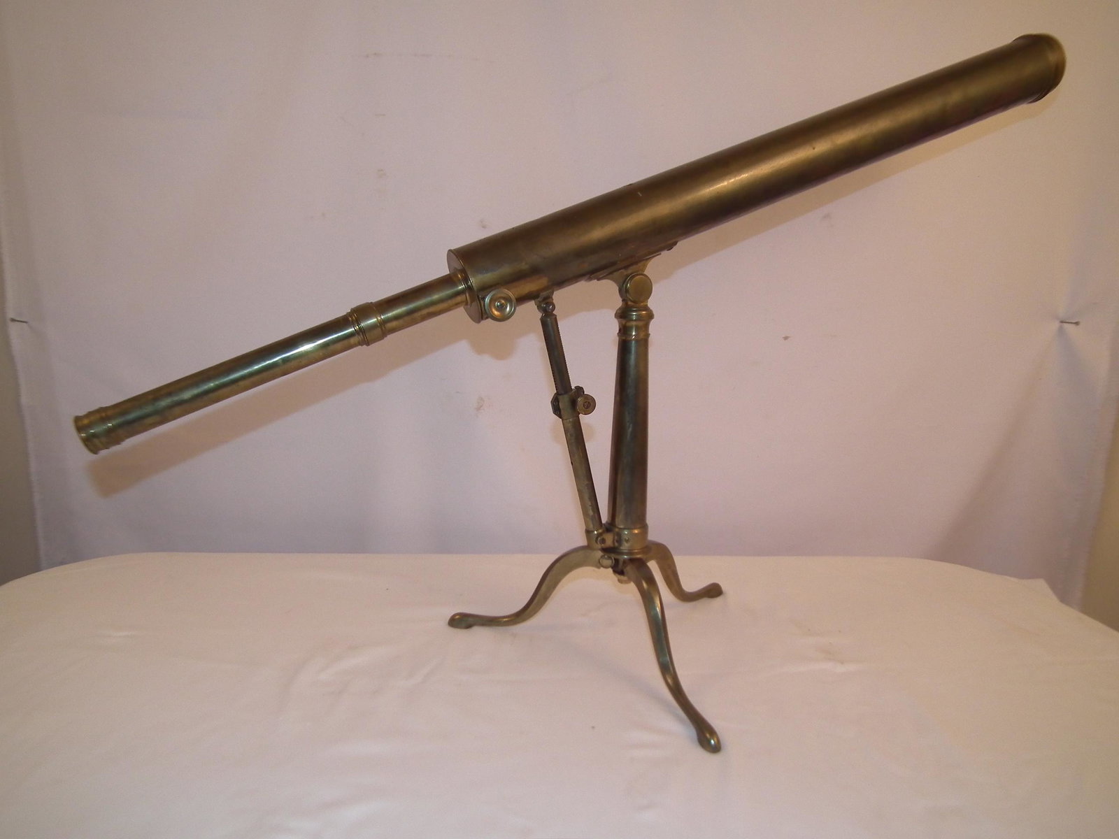 BERGE ANTIQUE BRASS TELESCOPE: Antique brass telescope with angle adjustable knob and tabletop tripod stand. Engraved BERGE LONDON, LATE RAMSDEN. 2.25 in diameter, 39.5 in long.
