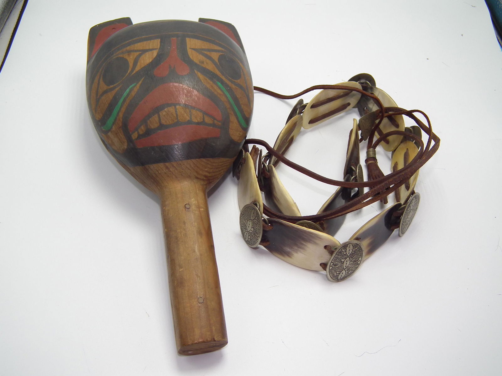 INDIAN RATTLE & STEER HORN BELT: 2 old Native American Indian items including: Northwest Coast painted wood rattle, 12 inches; and steerhorn and metal disc belt, 29 in long plus leather straps.