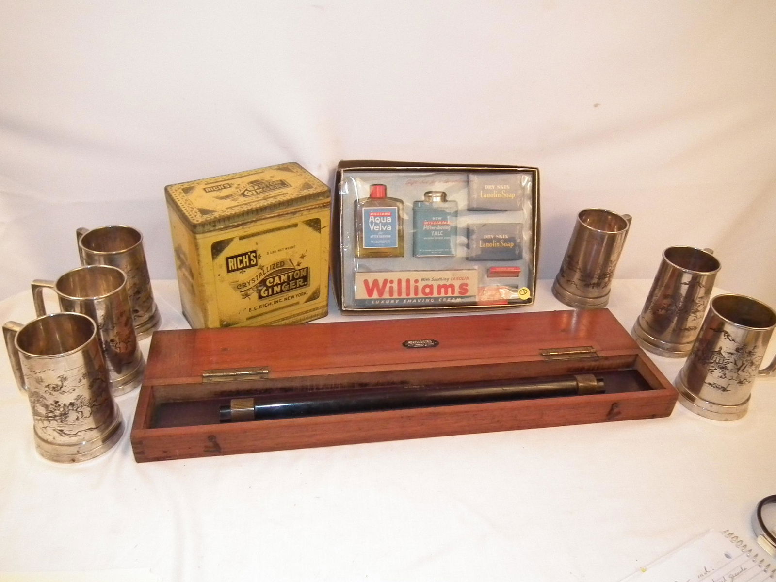 ESTATE LOT OF 9 ITEMS: Lot of 9 items including: antique Stanley of London 24 in rolling ruler in wood case; Rich's Canton Ginger tin, 5 lbs; set 6 silver plated mugs with Asian designs; and boxed set vintage men's cologne