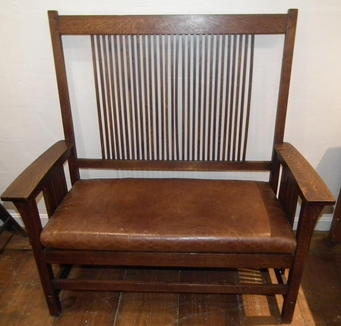 STICKLEY OAK SPINDLE SETTLE: Vintage dark oak Stickley spindle settle with leather cushion, has Stickley metal label 48 high x 48 wide x 22 inches deep.
